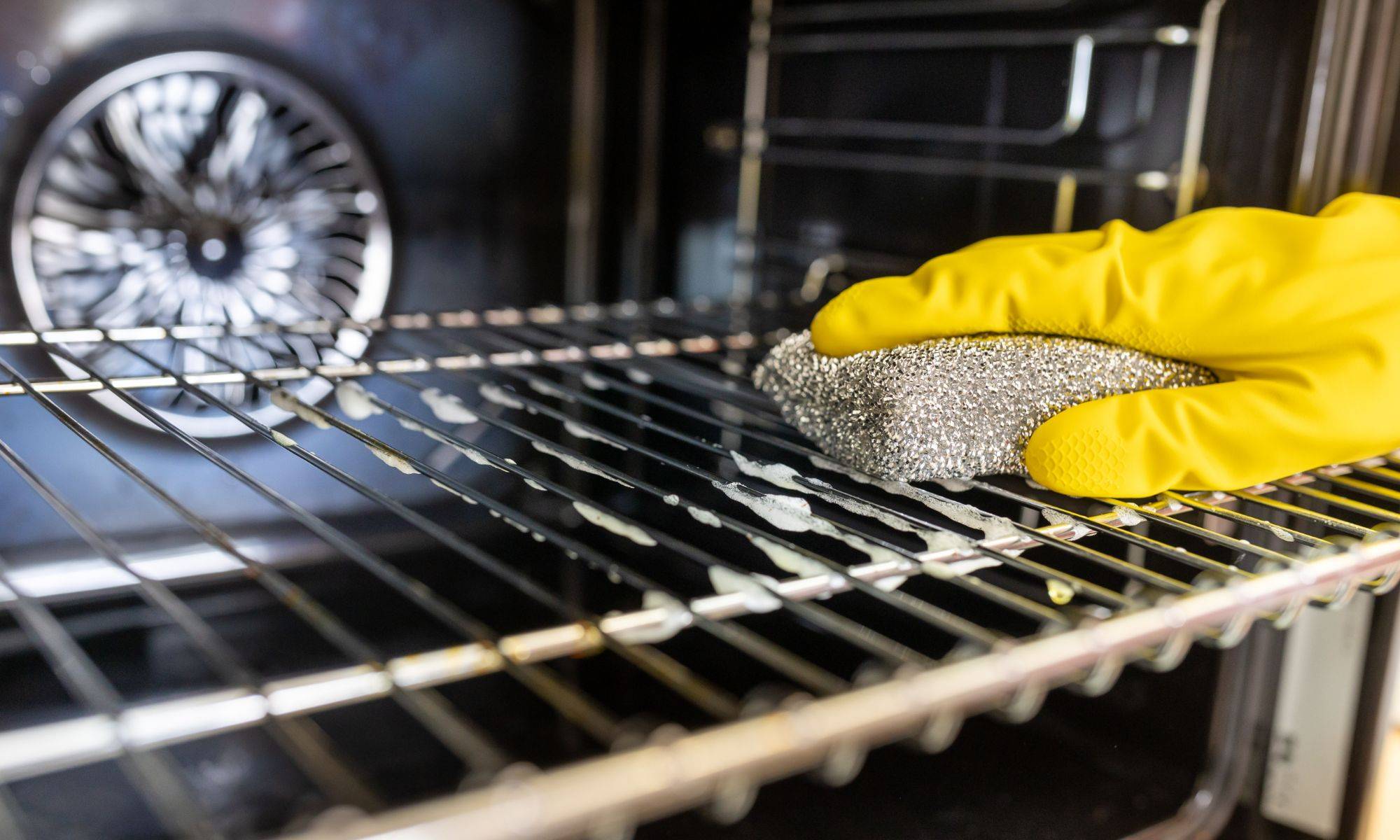 Hands With Gloves Wiping Oven Wire
